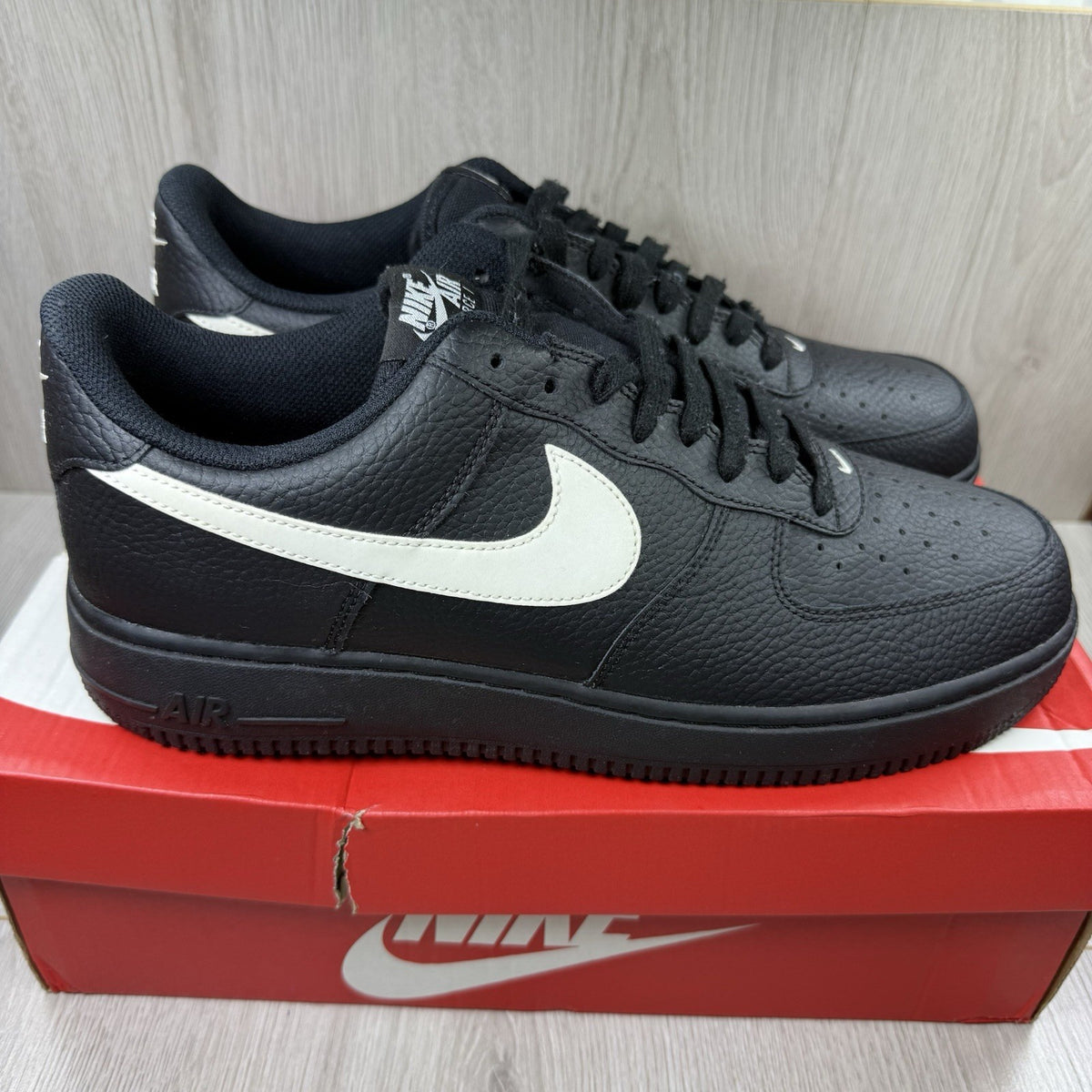 Nike Air Force 1 Low trainers black with white swoosh logo and sail accents.