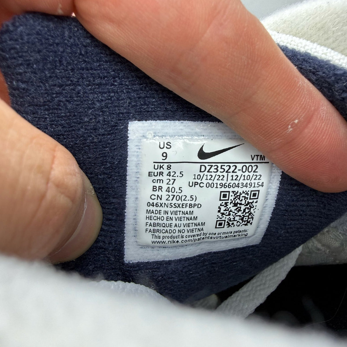 Nike Air Max 90 white trainers with obsidian and pewter accents, featuring logo detail.