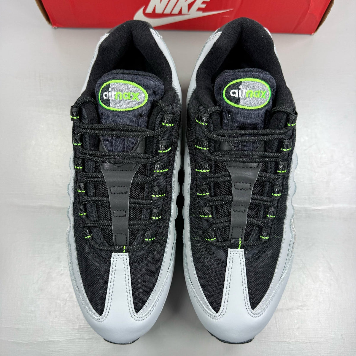 Nike Air Max 95 black trainers with green strike accents and textured upper.