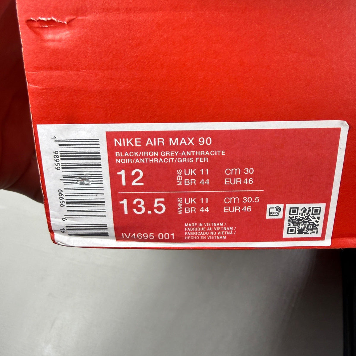 Nike black trainers with grey accents and Air Max cushioning detail.