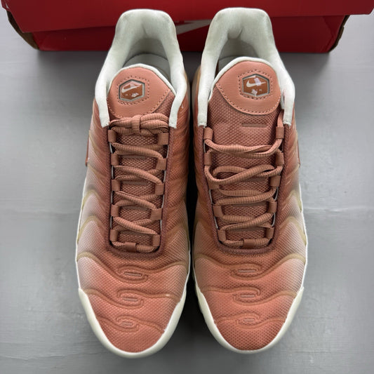 Nike Air Max Plus TN white trainers with peach accents and signature swoosh logo.