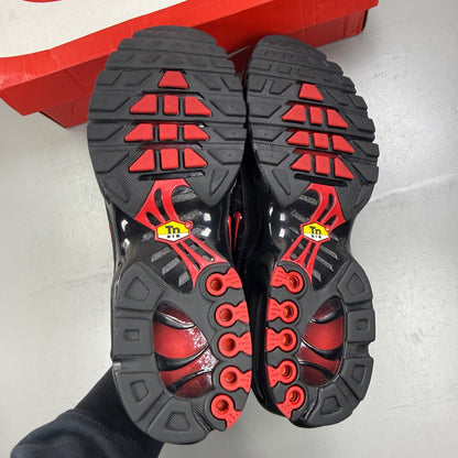 Nike Air Max Plus TN black trainers with red accents and iconic Tuned Air sole.