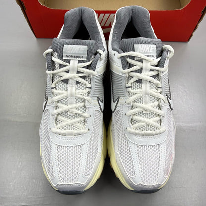 Nike Zoom Vomero 5 white trainers with grey accents and logo detailing.