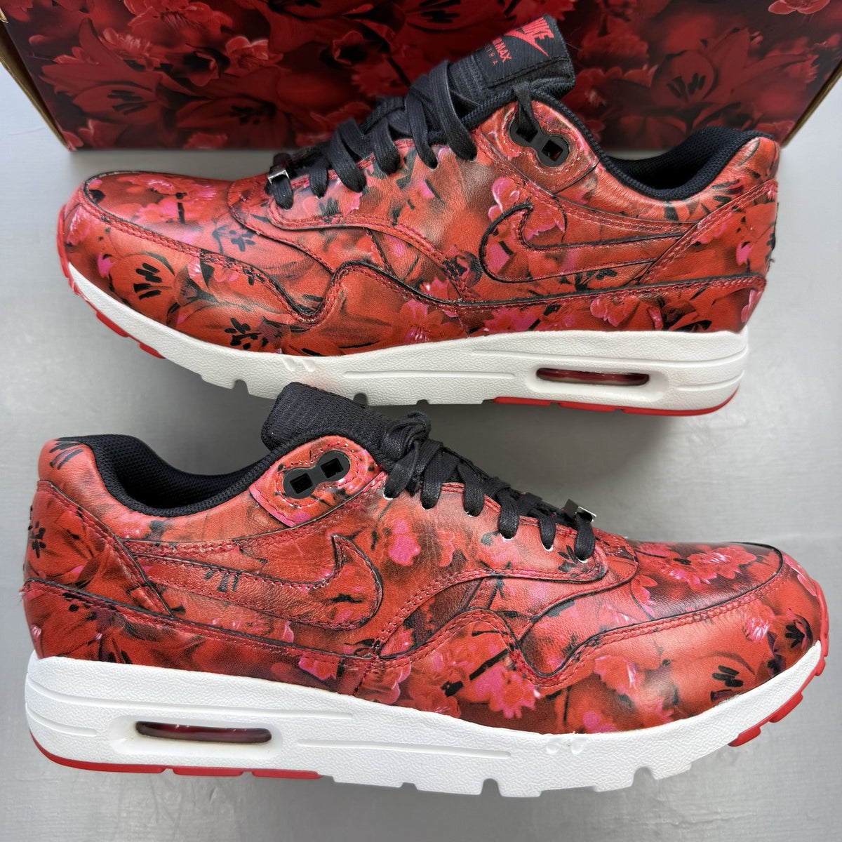 Nike Air Max 1 red trainers with white accents and classic logo detail.