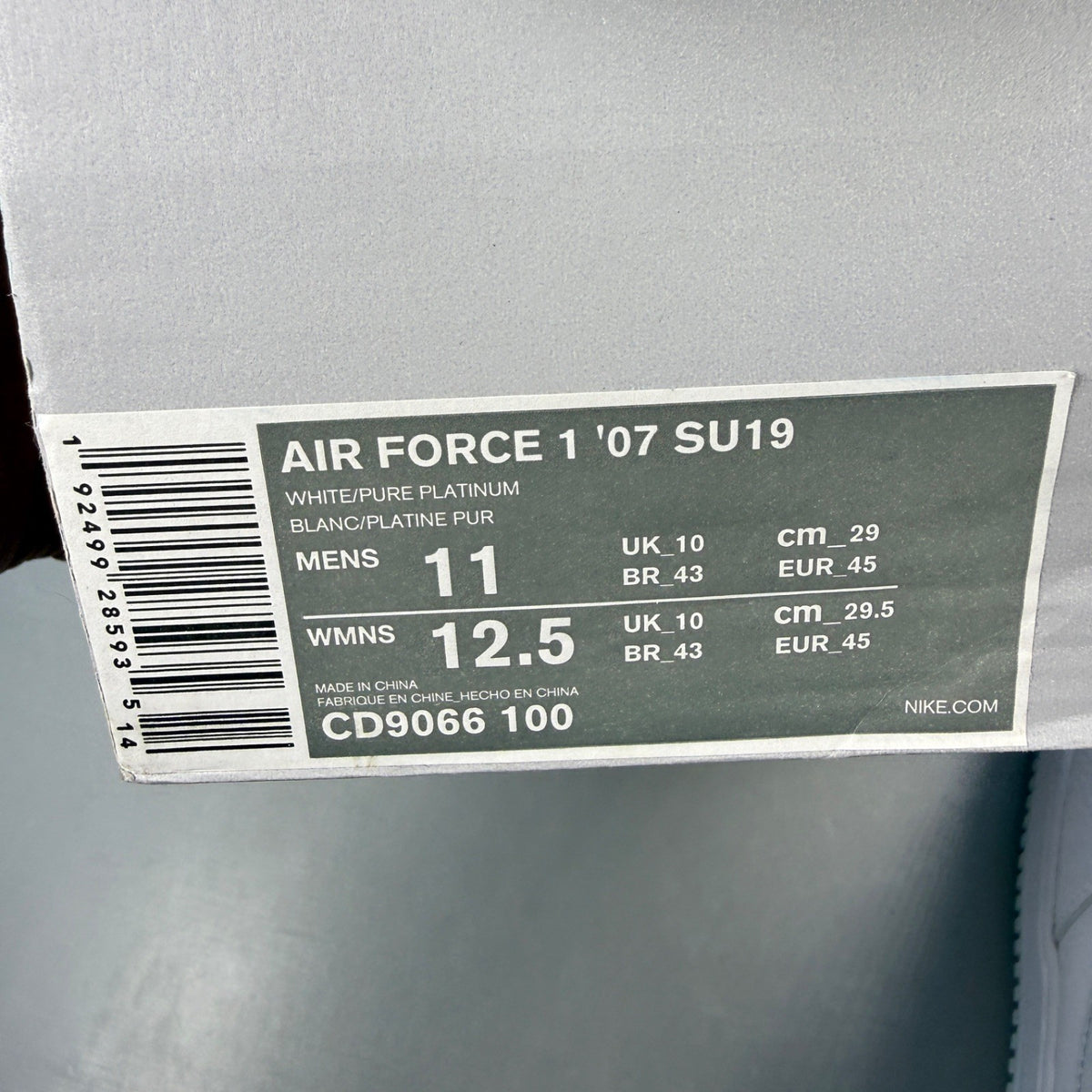 Nike Air Force 1 white trainers with pure platinum grey accents and classic logo.