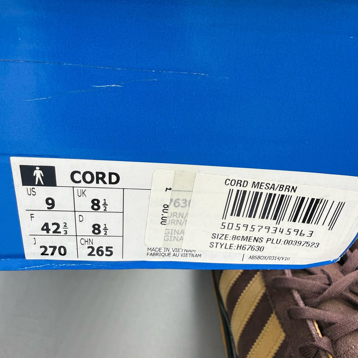 Adidas brown trainers with gold accents and gum sole, featuring iconic three stripes logo.