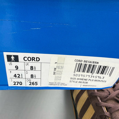 Adidas brown trainers with gold accents and gum sole, featuring iconic three stripes logo.