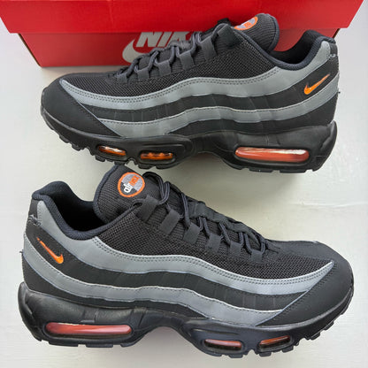 Nike Air Max 95 black grey trainers with safety orange accents and logo detailing.