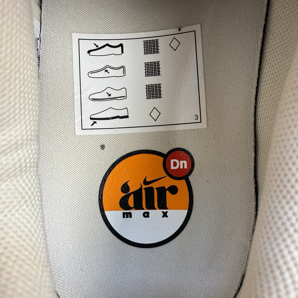 Nike Air Max DN trainers white with light brown accents and logo detail.