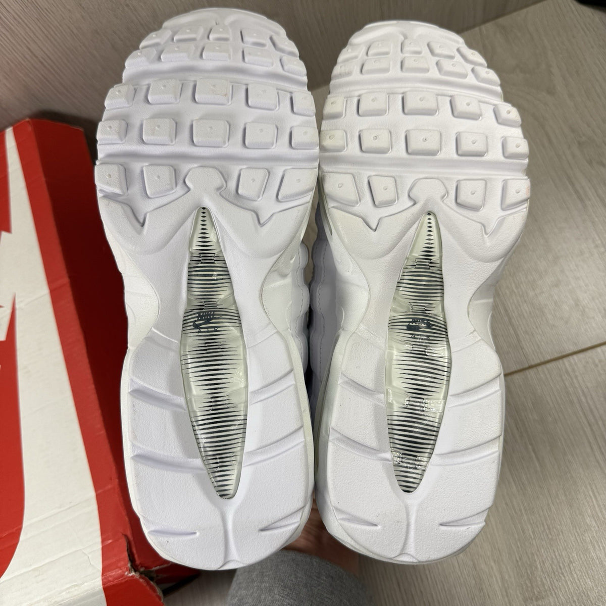 Nike Air Max 95 trainers white mesh upper with signature swoosh logo and reflective details.