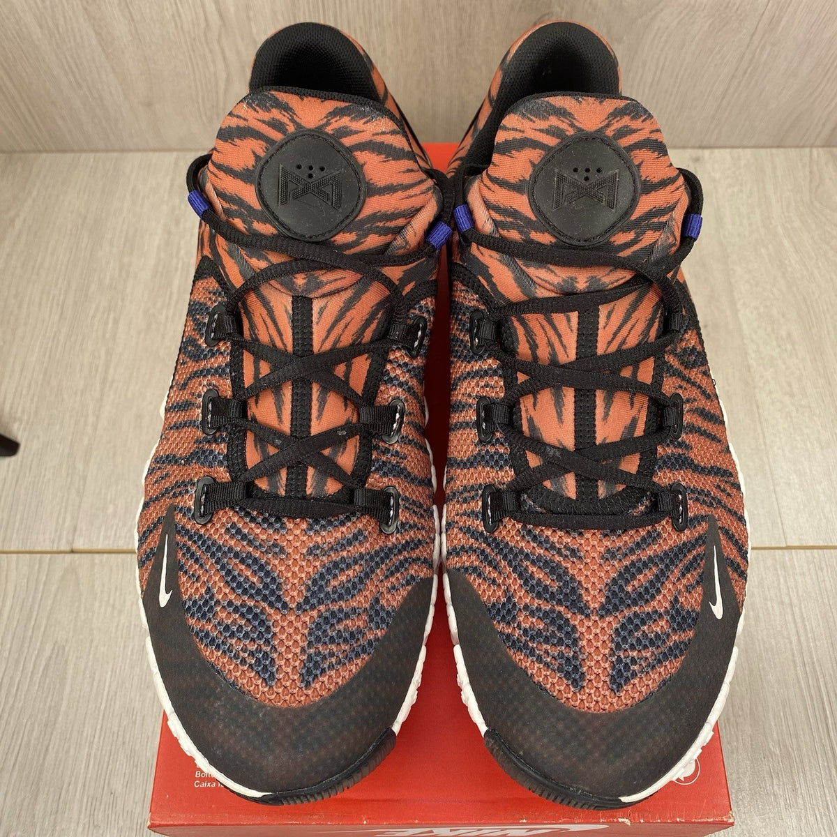 Nike Free Metcon 4 trainers black with tiger burnt sunrise accents and logo detail.