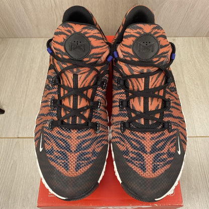 Nike Free Metcon 4 trainers black with tiger burnt sunrise accents and logo detail.