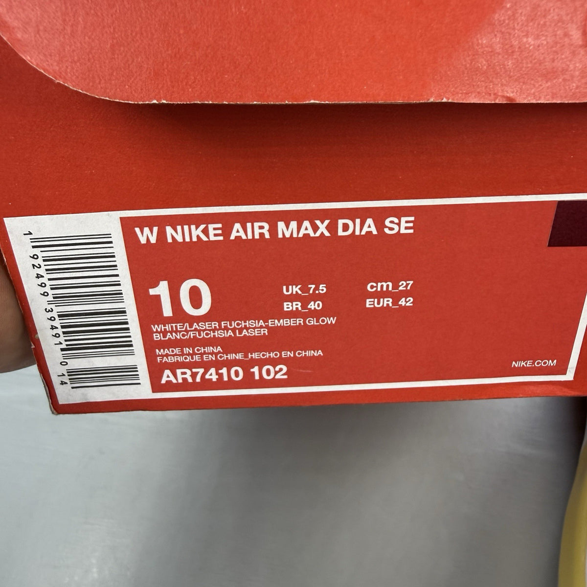 Nike Air Max Dia SE white trainers with laser fuchsia and gold accents, sleek design.