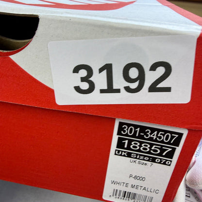 Nike white trainers with elemental pink and silver accents, featuring logo details.