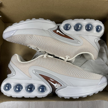 Nike Air Max DN trainers white with light brown accents and logo detail.