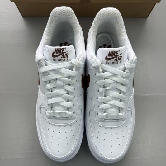 Nike Air Force 1 trainers white with brown accents and signature logo detail.