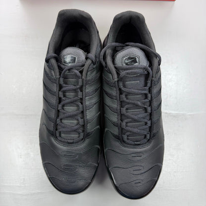 Nike Air Max Plus TN black leather trainers with distinctive wave pattern and logo.