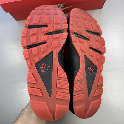 Nike Air Huarache trainers red and black with distinctive logo and unique design details.