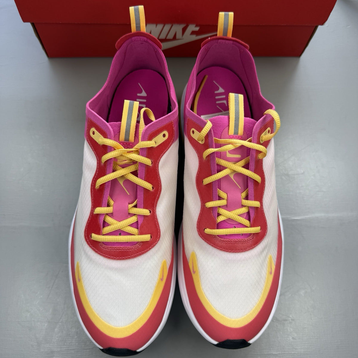 Nike Air Max Dia SE white trainers with laser fuchsia and gold accents, sleek design.