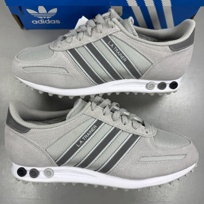 Adidas grey athletic shoes with white accents and classic three-stripe logo.