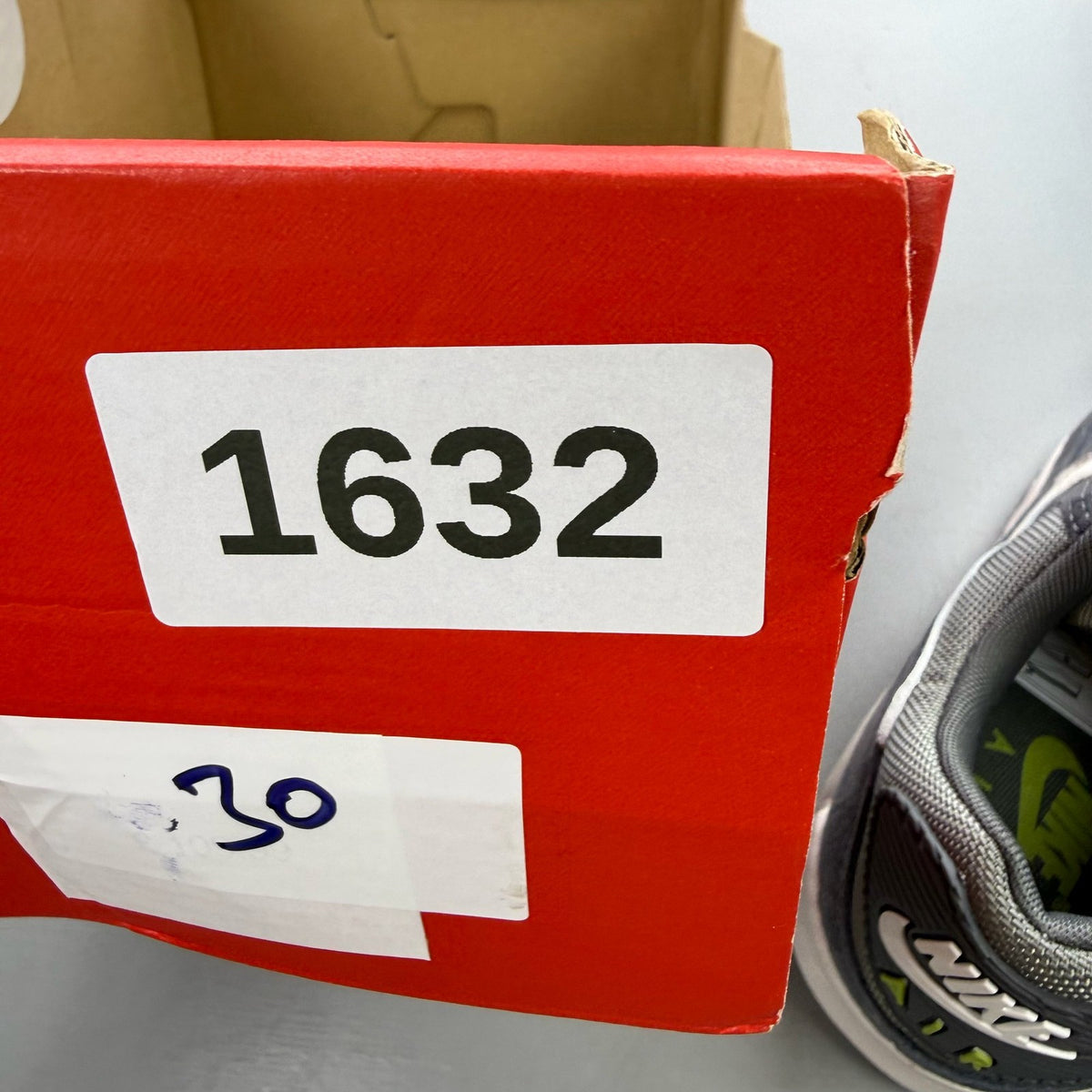 Nike Air Max 90 PRM grey trainers with white accents and distinctive logo details.