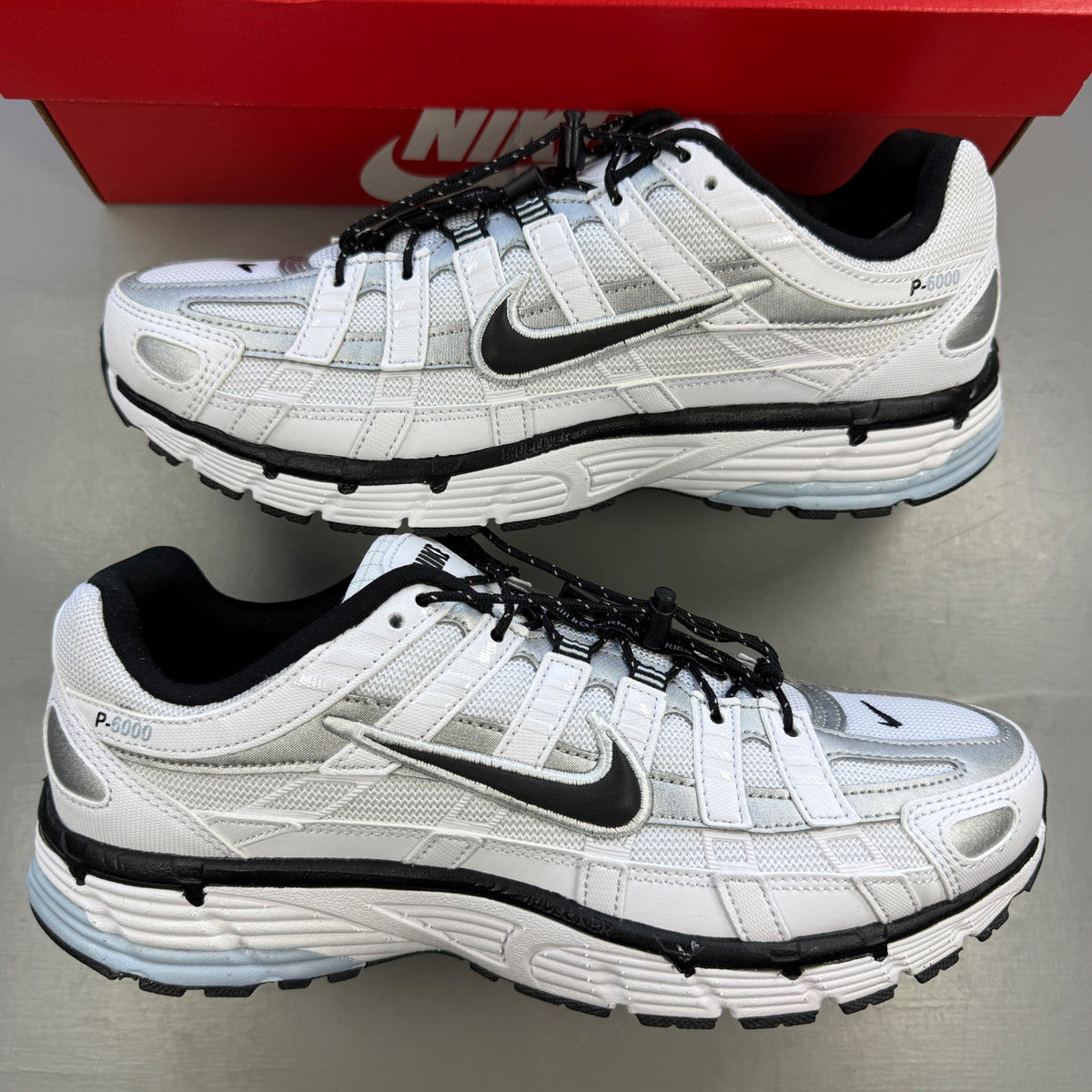Nike white trainers with light armoury blue and black accents, featuring logo details.