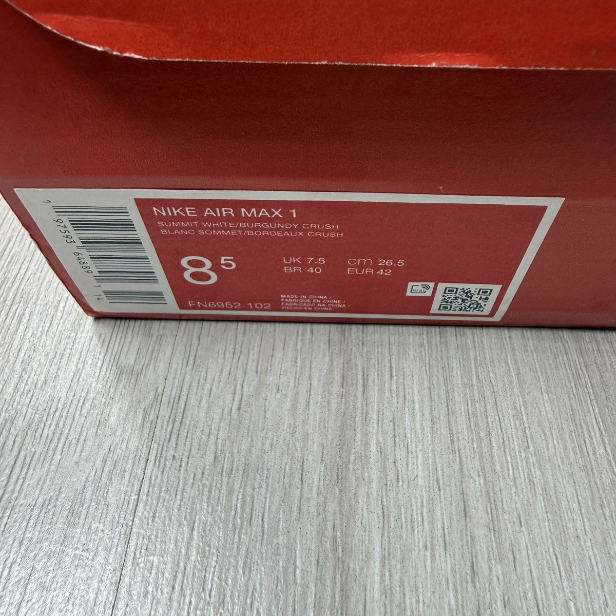 Nike Air Max 1 red trainers with white accents and signature swoosh logo.
