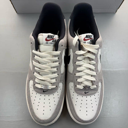 Nike Air Force 1 grey trainers with black accents and signature swoosh logo.