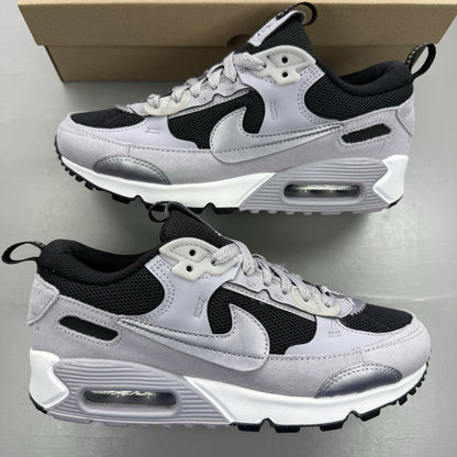 Nike Air Max 90 Futura black trainers with grey and white accents, sleek design.
