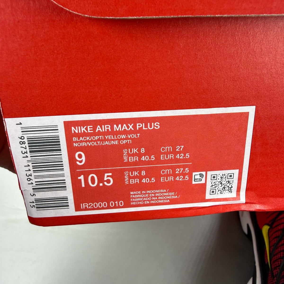 Nike Air Max Plus TN black trainers with light crimson and volt accents, logo on tongue.