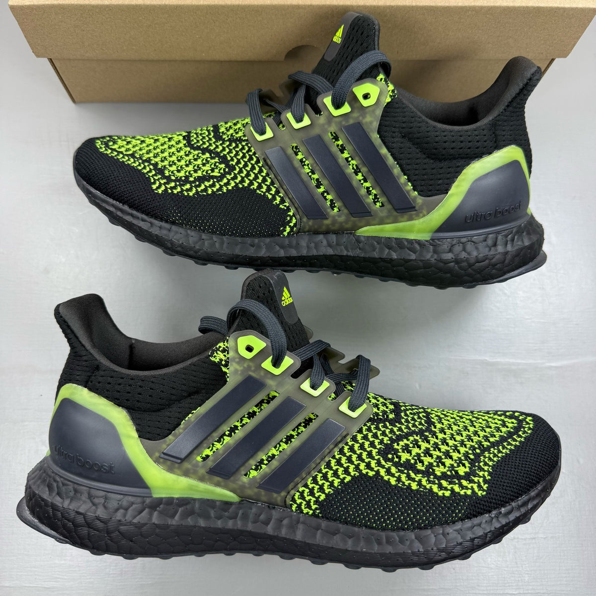 Adidas black Ultraboost 1.0 trainers with Lucid Lemon accents and breathable mesh upper.