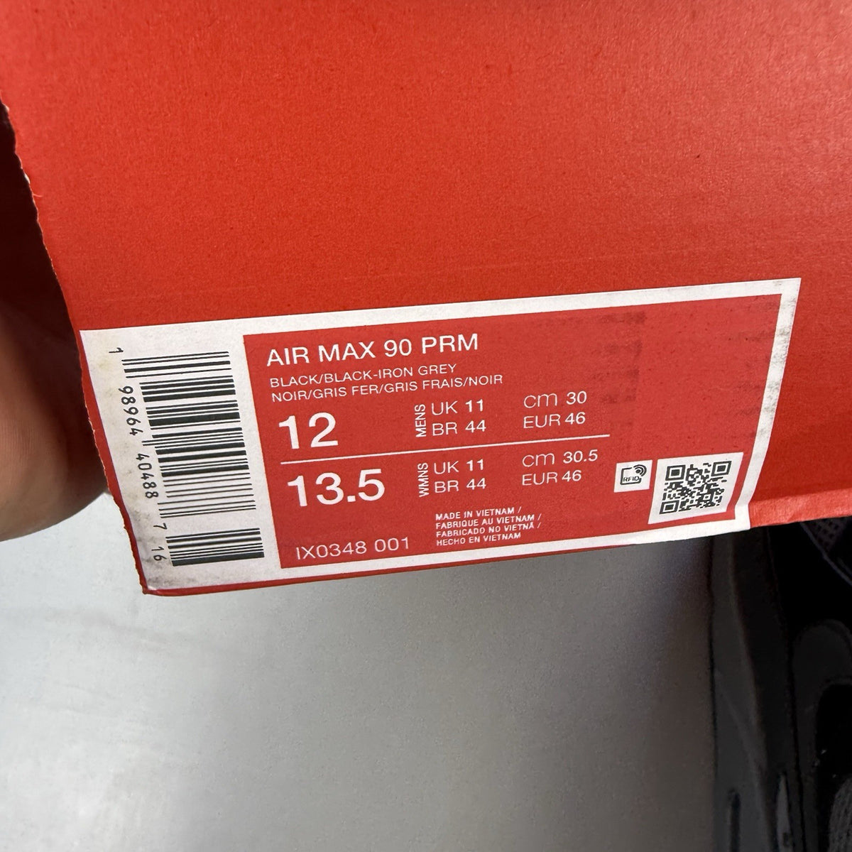Nike Air Max 90 black trainers with grey accents and iconic logo detail.