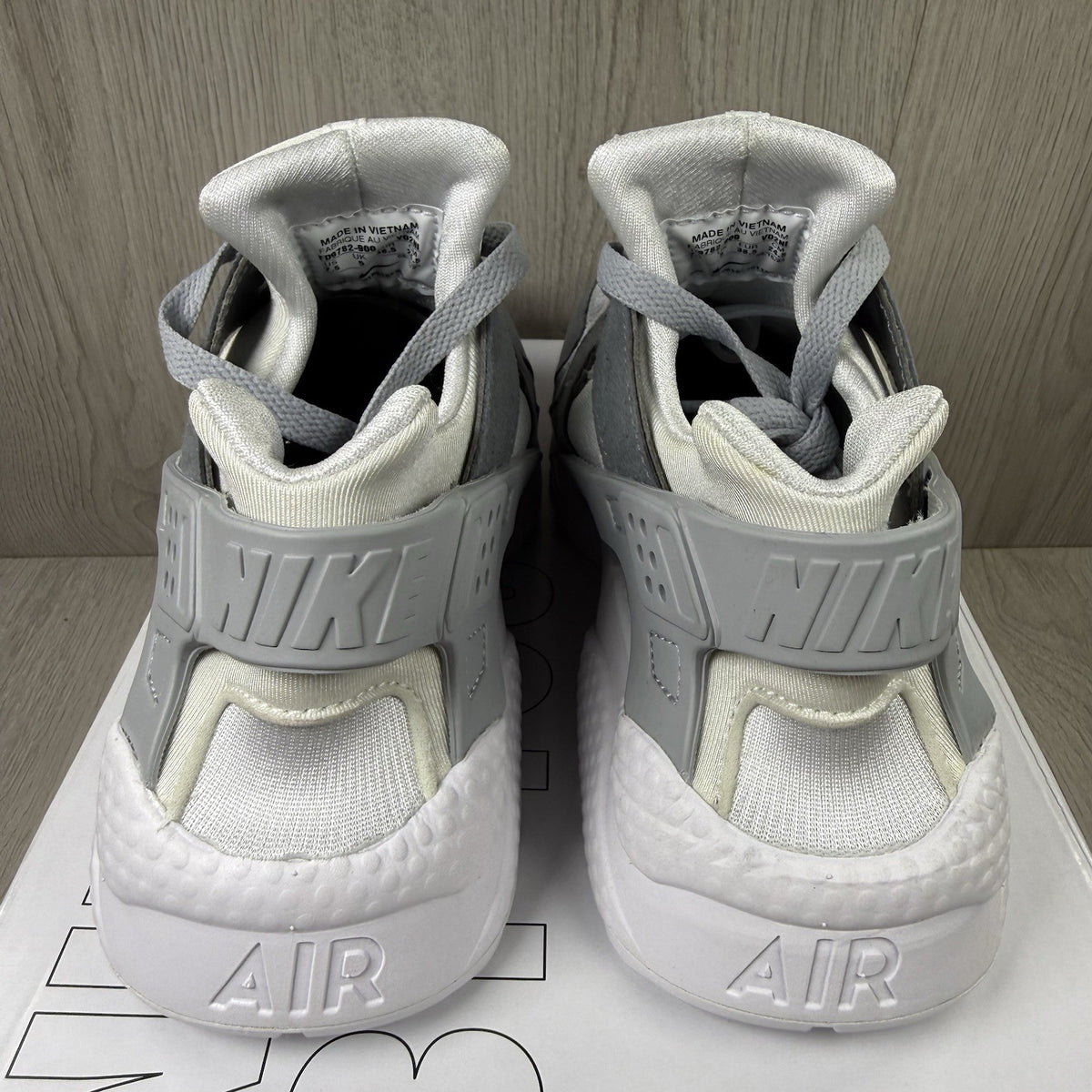 Nike white trainers with grey accents and signature logo on the tongue.