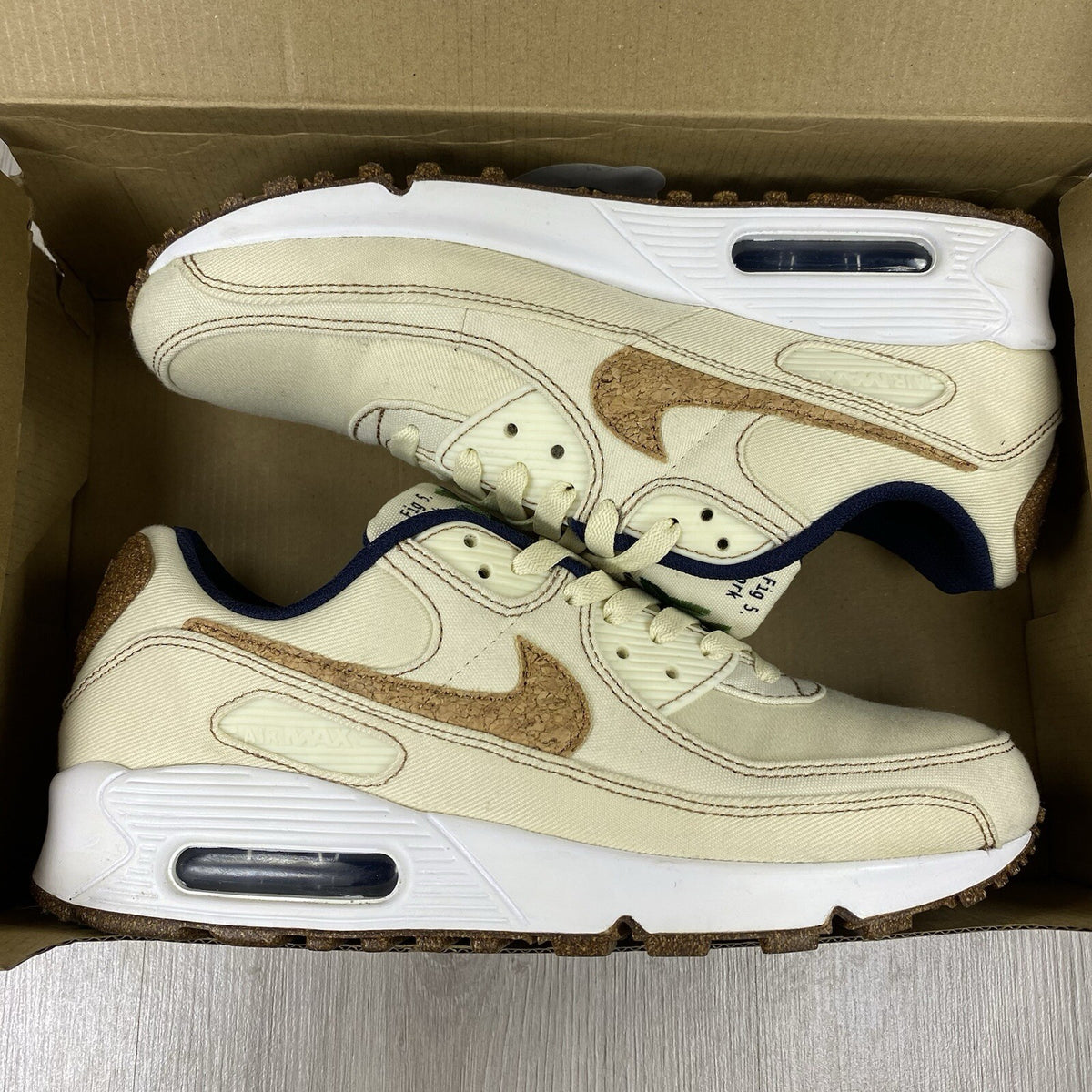 Nike Air Max 90 SE white trainers with cork accents and logo detail.