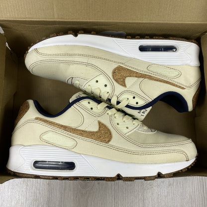 Nike Air Max 90 SE white trainers with cork accents and logo detail.