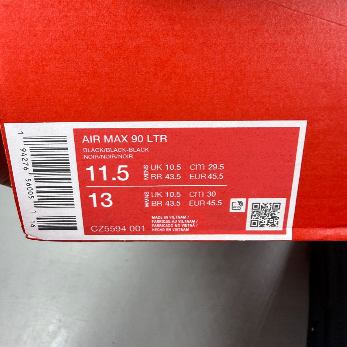 Nike Air Max 90 black leather trainers with logo detailing and textured upper.