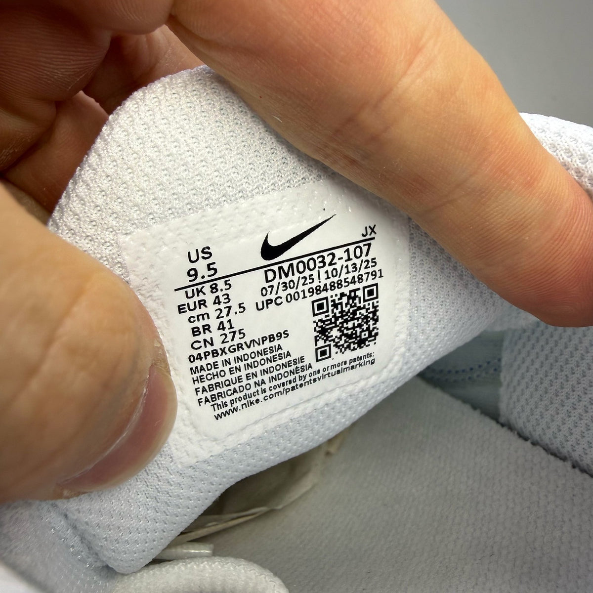 Nike Air Max Plus TN white trainers with blue accents and signature logo details.
