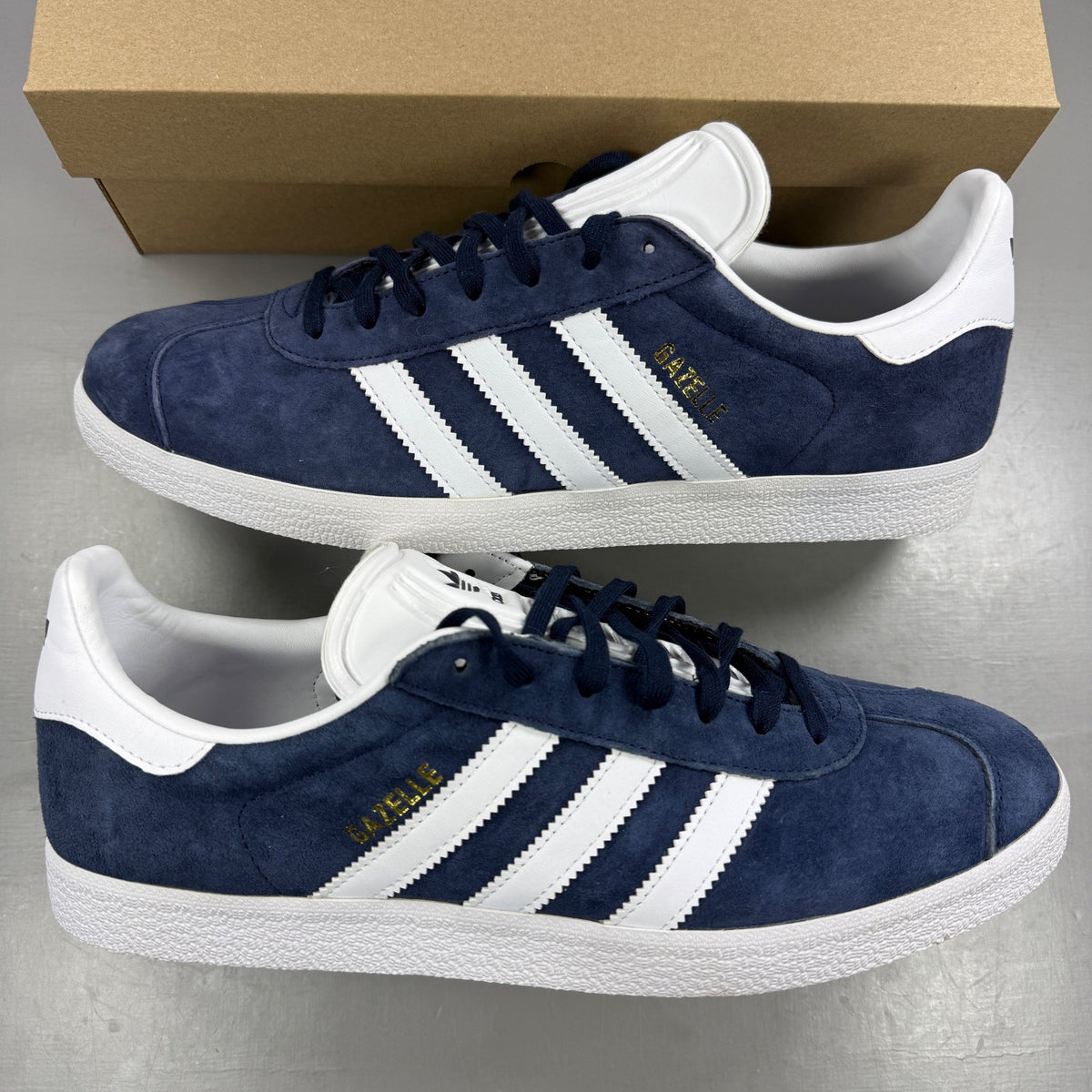 Adidas blue suede trainers with white stripes and logo detailing.
