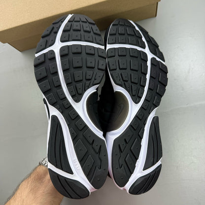 Nike Air Presto black trainers with white accents and breathable mesh upper.