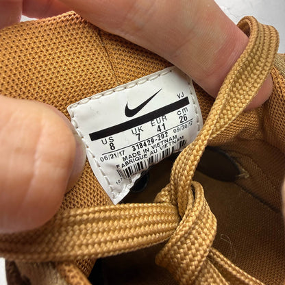 Nike brown trainers with gum sole and white accents, featuring iconic Huarache design.