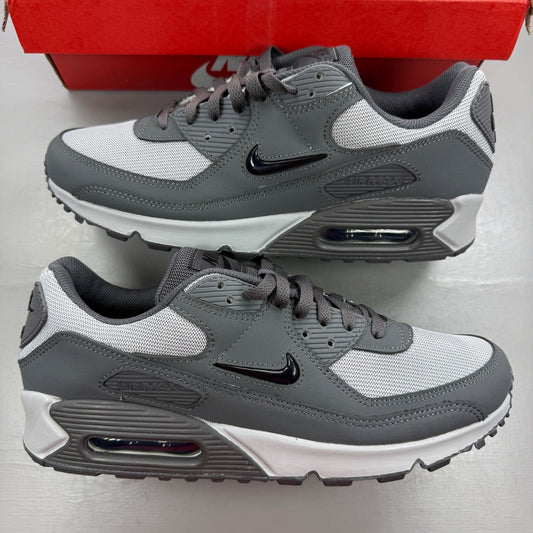 Nike Air Max 90 grey trainers with jewel accents and signature swoosh logo.