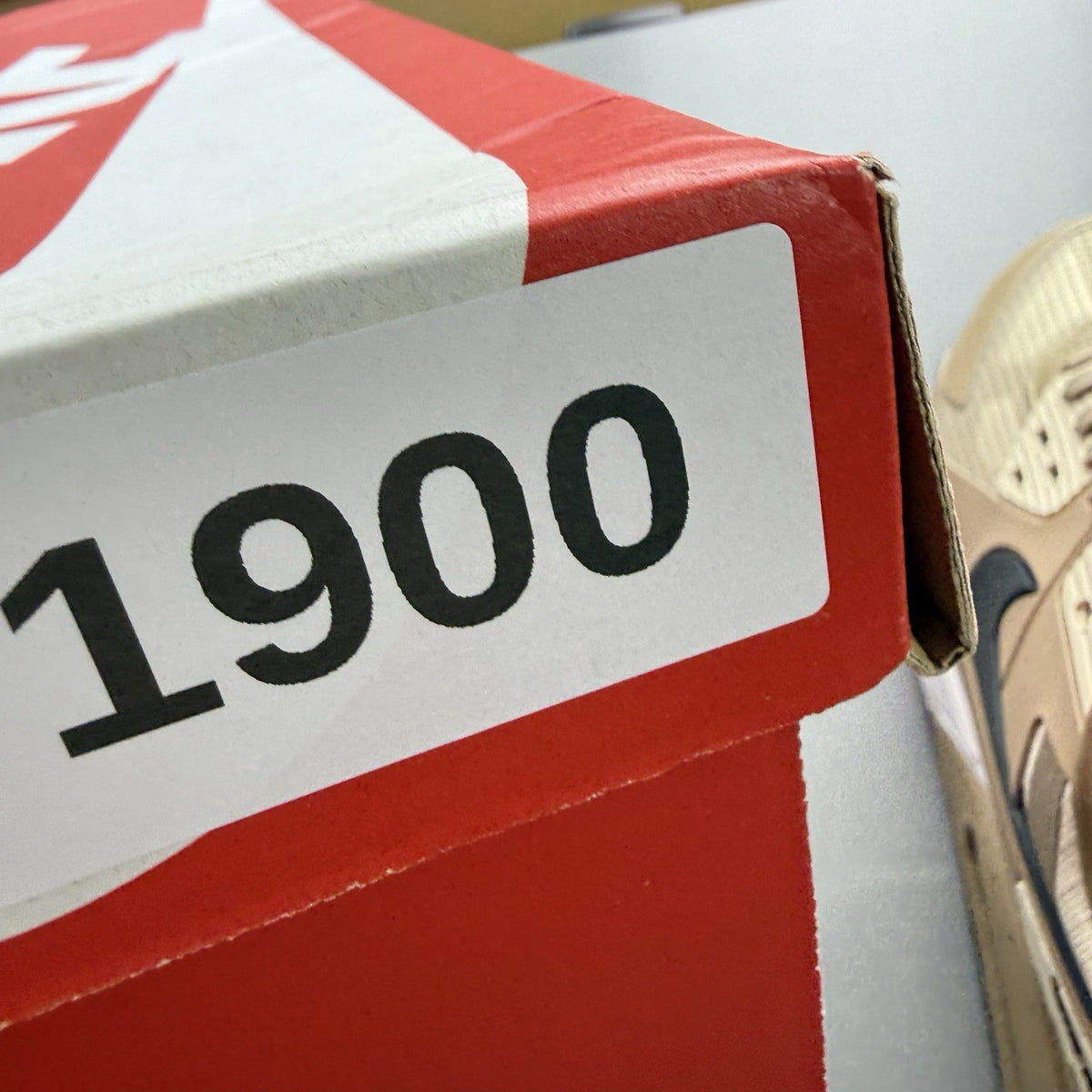 Nike Air Max 90 Drift beige trainers with black and brown accents, featuring logo detail.