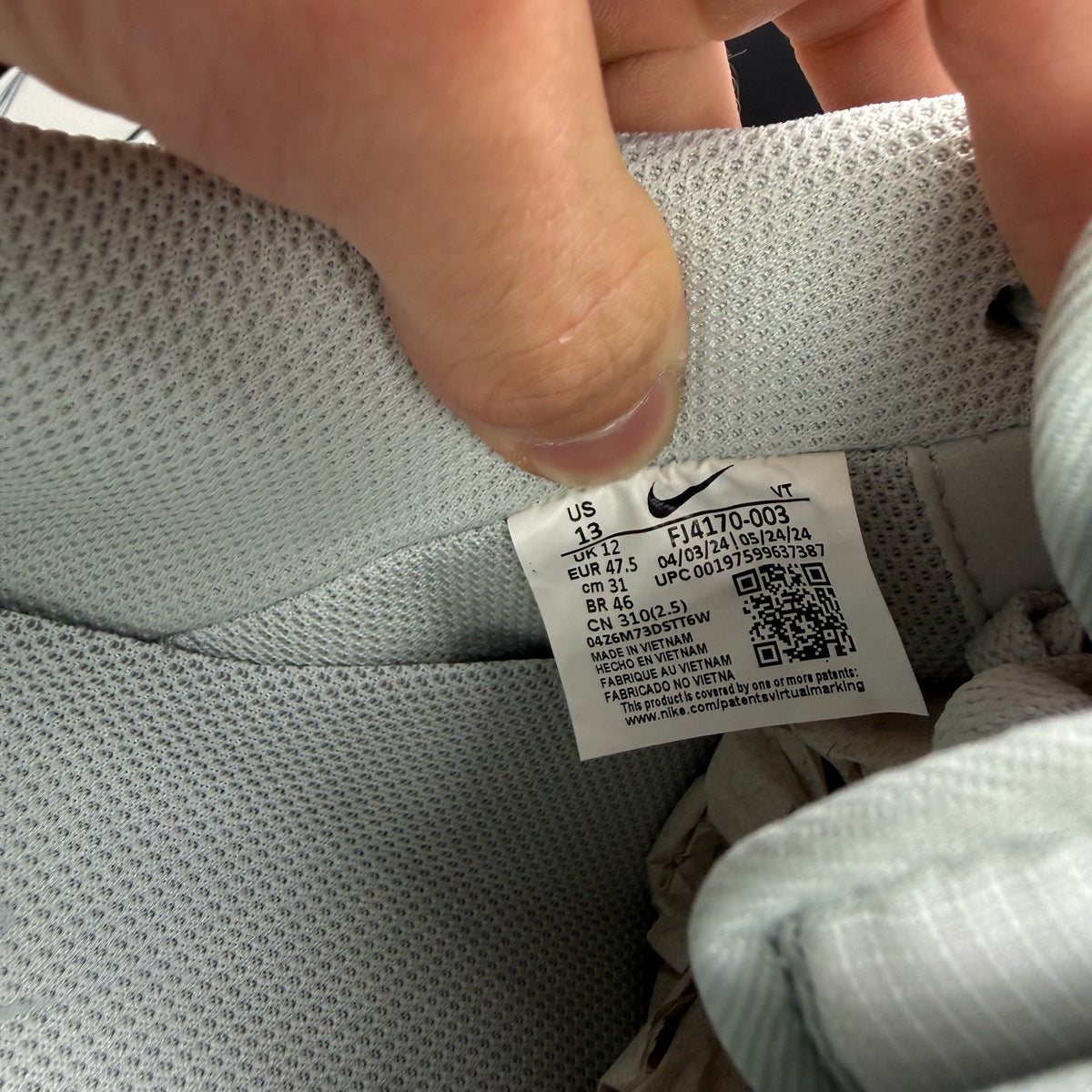 Nike Air Force 1 grey low-top sneakers with light silver accents and white sole.