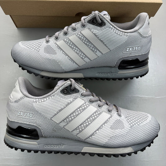 Adidas grey trainers with woven texture and classic three-stripe logo.