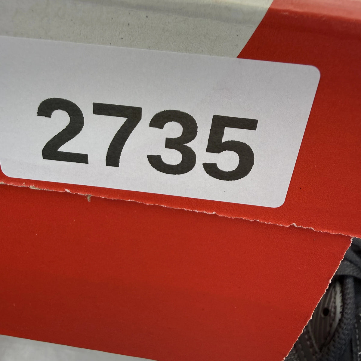 Nike Air Max 90 grey trainers with black and white accents, featuring logo details.