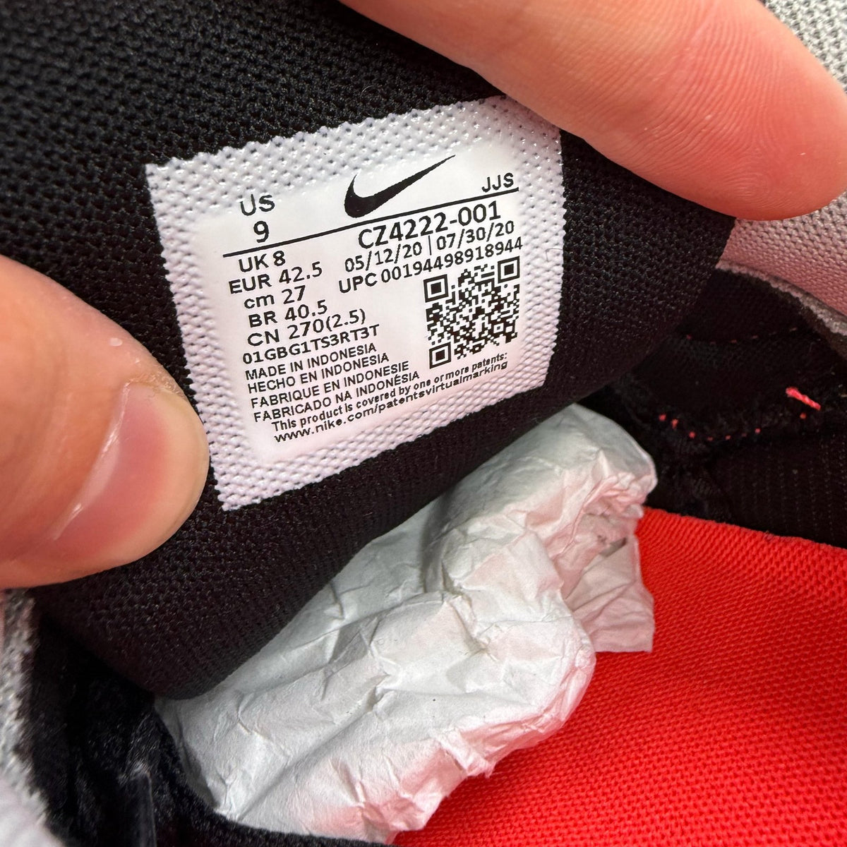 Nike Air Max 90 black trainers with radiant red and wolf grey accents, logo detail.