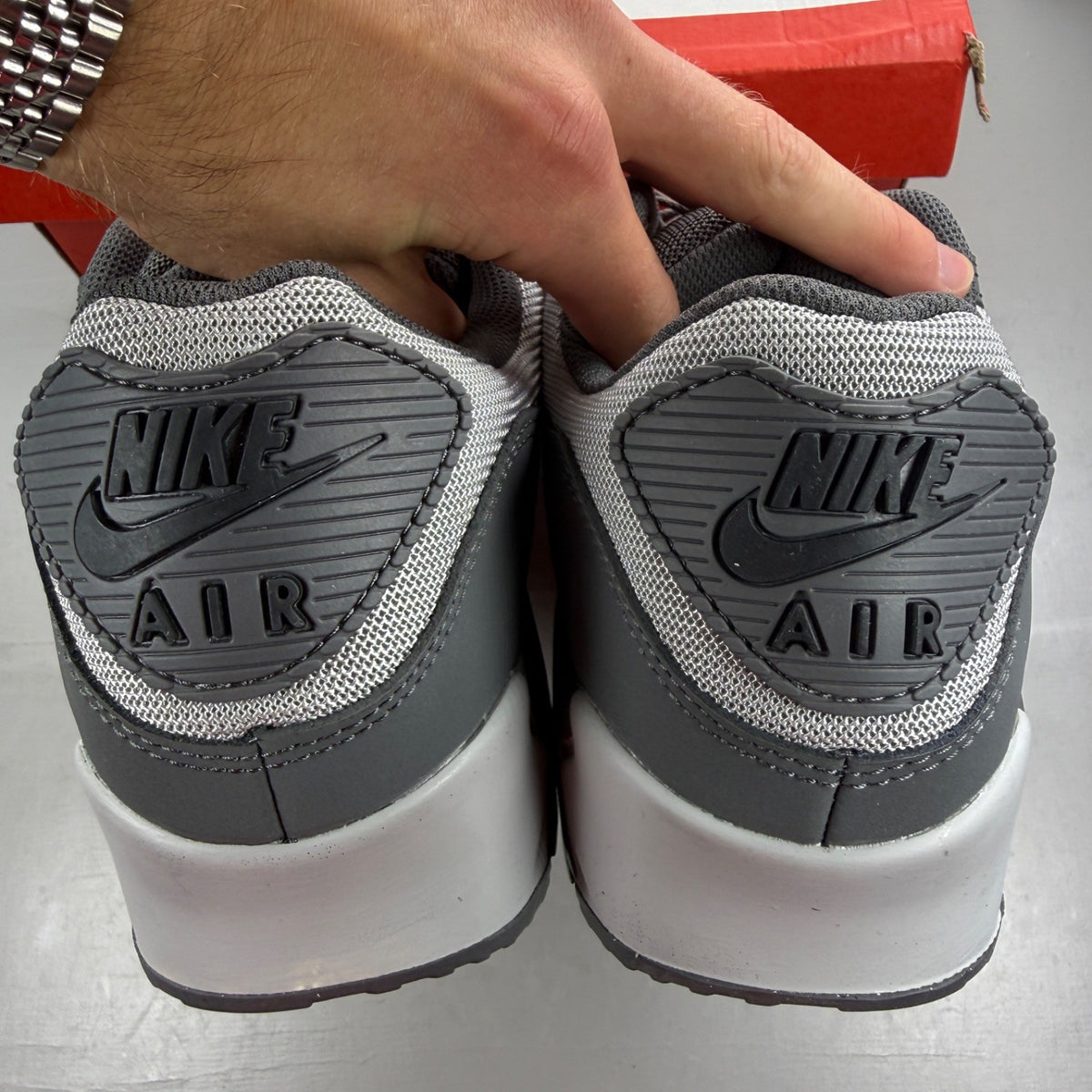 Nike Air Max 90 grey trainers with jewel accents and textured upper.
