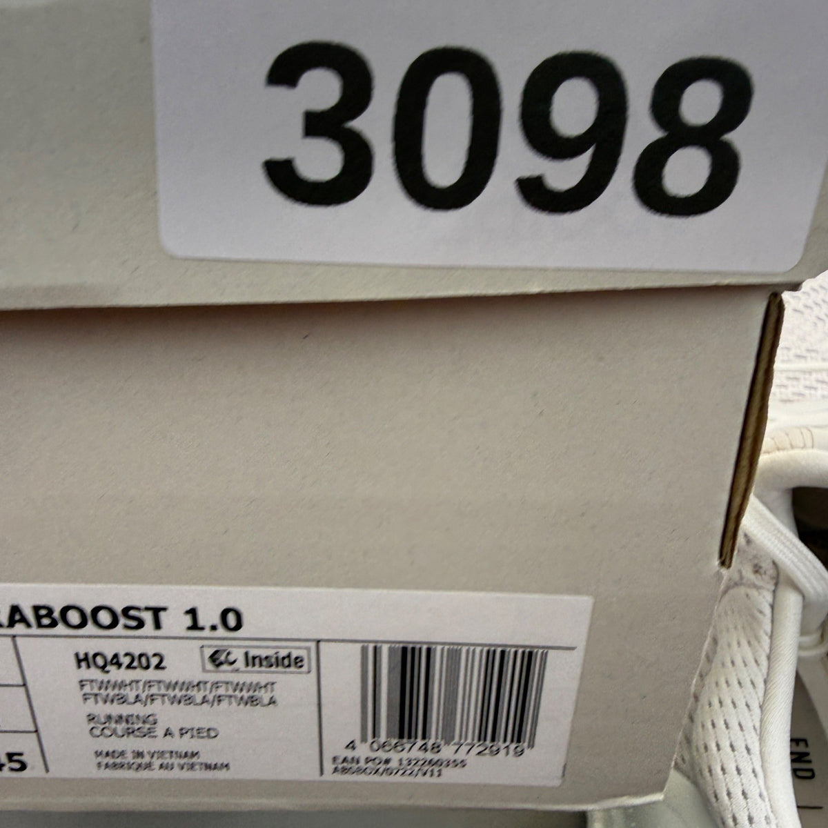Adidas Ultra Boost 1.0 white running trainers with textured knit upper and signature three stripes.