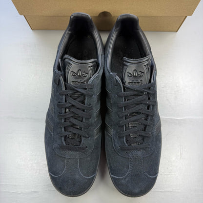 Adidas black trainers in suede with iconic three stripes logo and classic design.