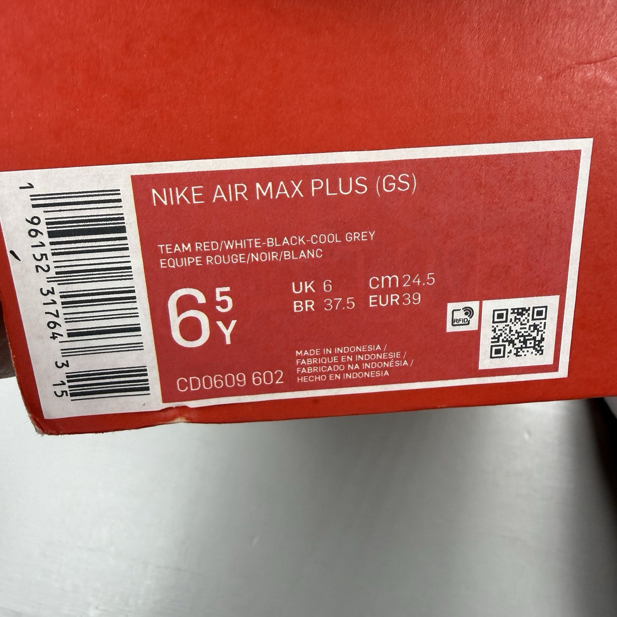 Nike Air Max Plus TN red trainers with grey and black accents, featuring signature logo.